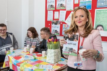 staff member holding Happy Cafe leaflet