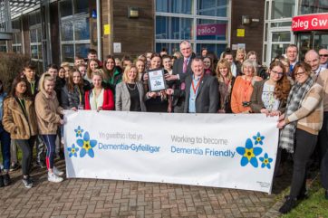 Staff and students outside holding Dementia Banner 