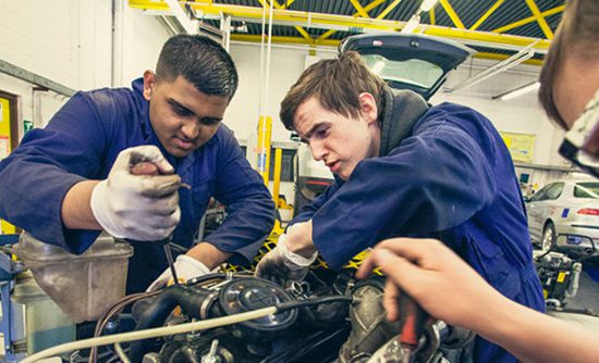 2 students working on a car engine