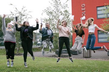 students celebrating outside campus