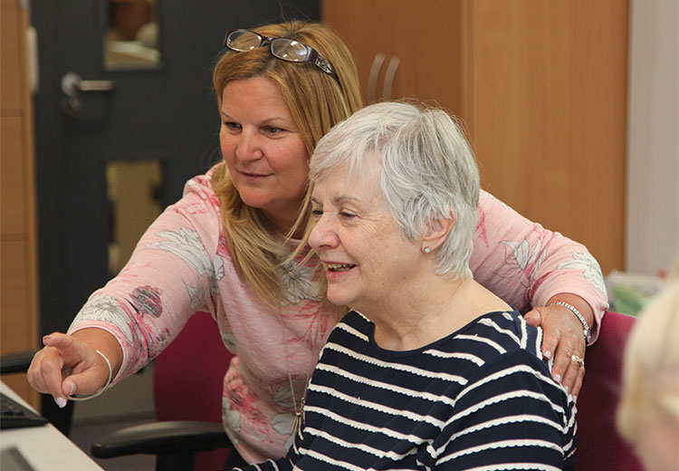 Community learner and tutor looking at screen