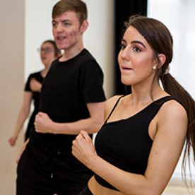 male and female preforming dance routine in studio