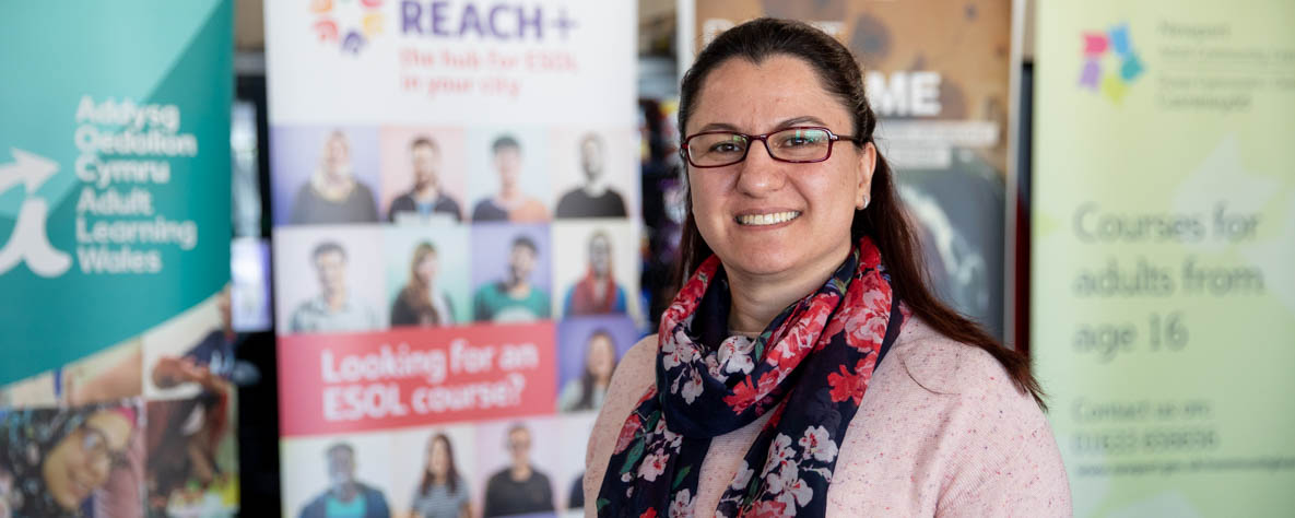 Woman standing in front of Reach+ banner