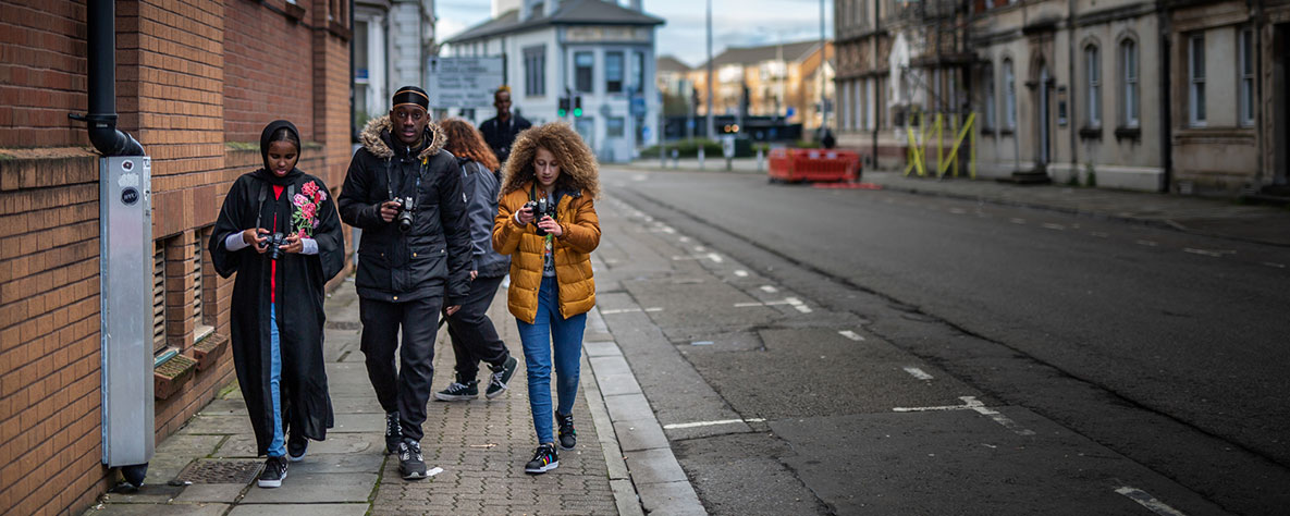 Photography learners walking with cameras in street