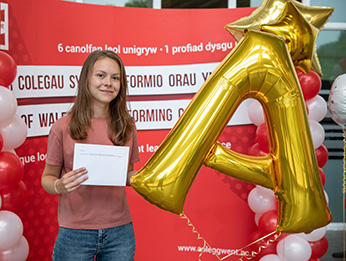 Hannah James with large gold A star balloon