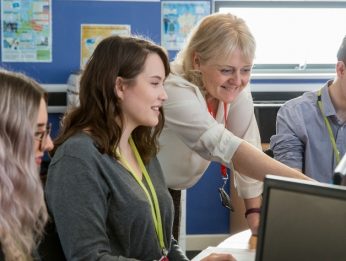 Students being supported by a tutor in the classroom