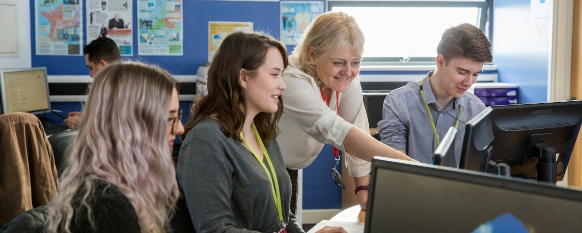 Students being supported by a tutor in the classroom