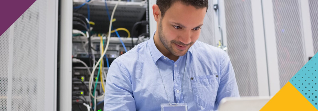 it-networking-sector-header Man using laptop in network room
