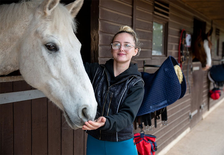 Learner with horse in stable