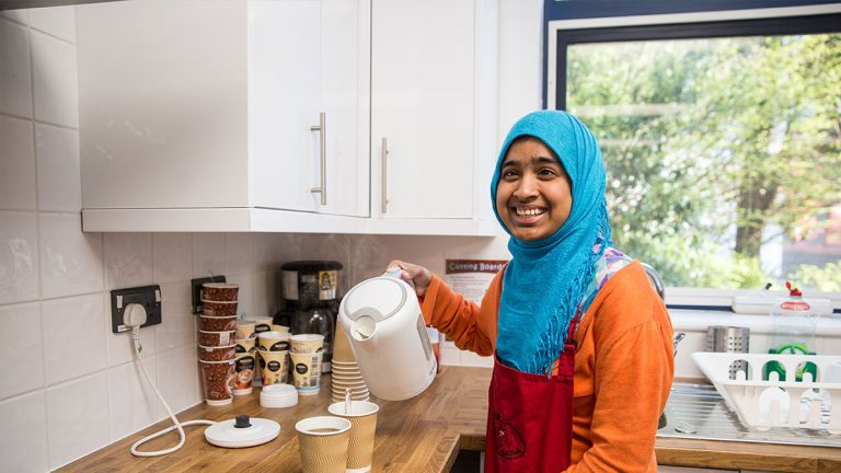 Learner with kettle in kitchen