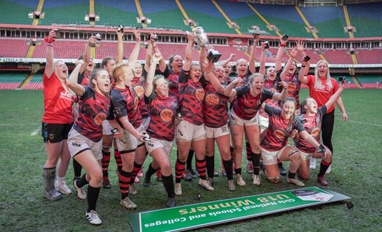 Womens rugby team celebrating with cup