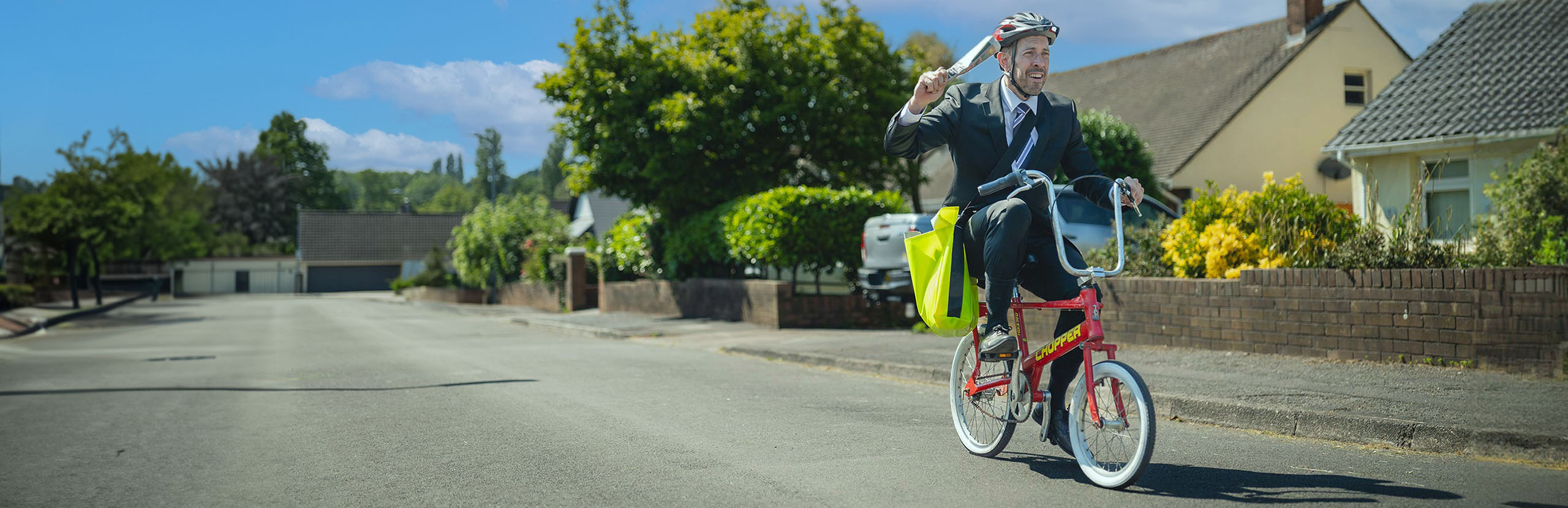 Man riding Raleigh Chopper bike delivering newspapers