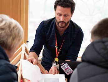 Staff member talking to parent and young student