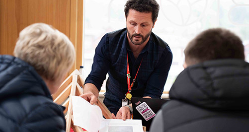 Staff member talking to parent and young student