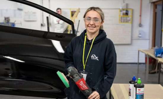 Apprentice in body repair workshop