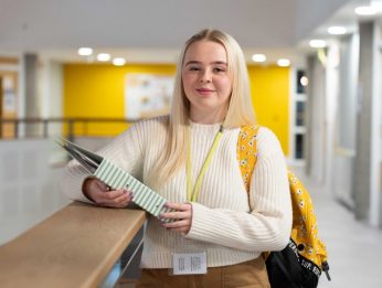 Student with folder on campus