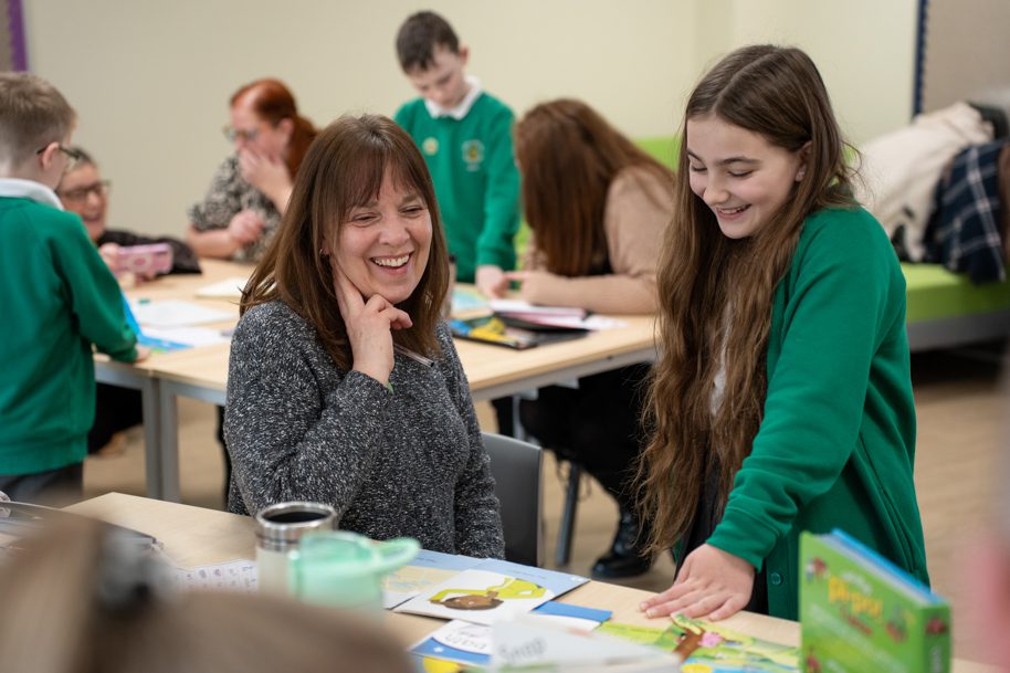 Parent learning Welsh with child at school