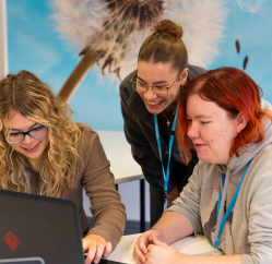 Tutor and students around laptop