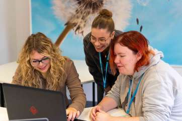 Page Thumnail Tutor and students around laptop