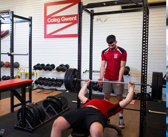 Student lifting weights in a gym