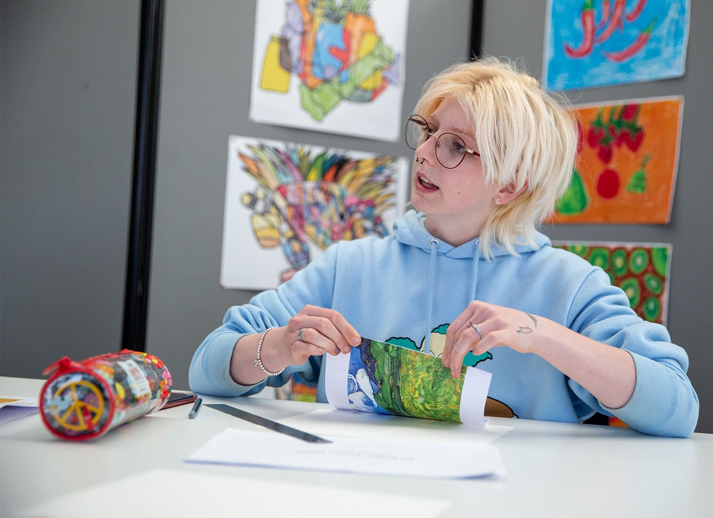 Art student surrounded by paintings in class