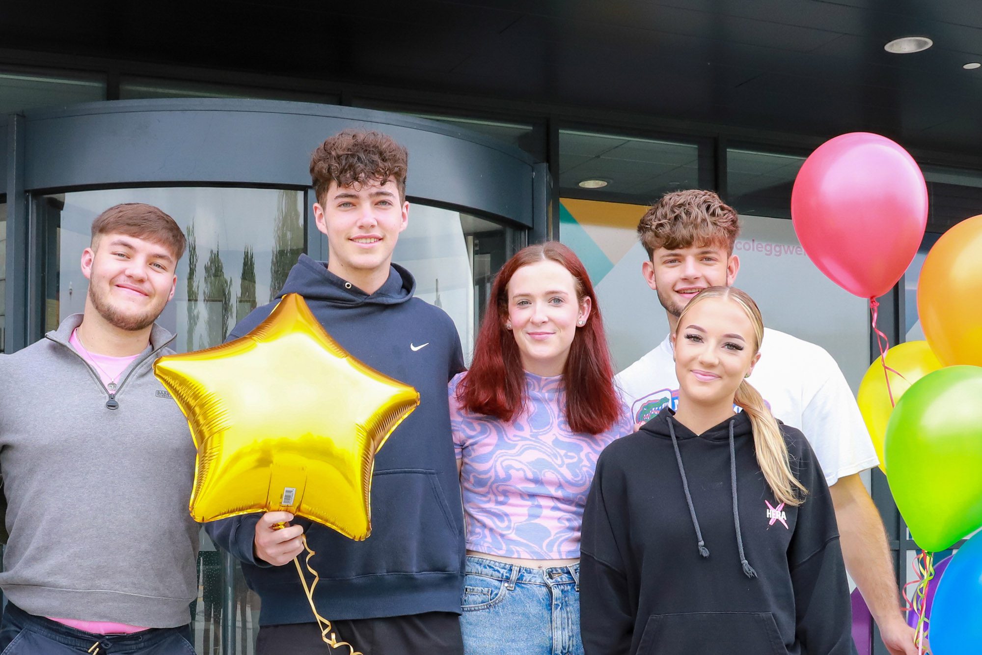 Students celebrating with balloons outside TLZ campus