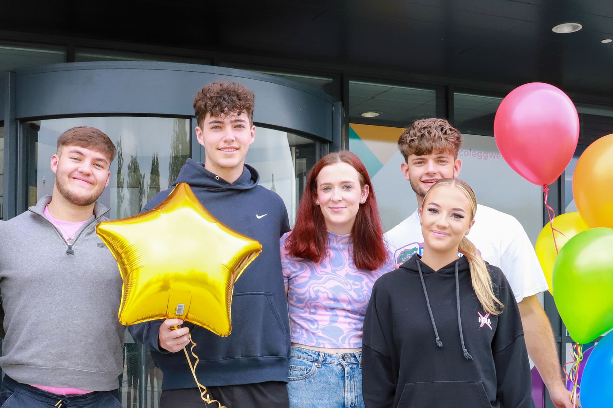 Students celebrating with balloons outside TLZ campus