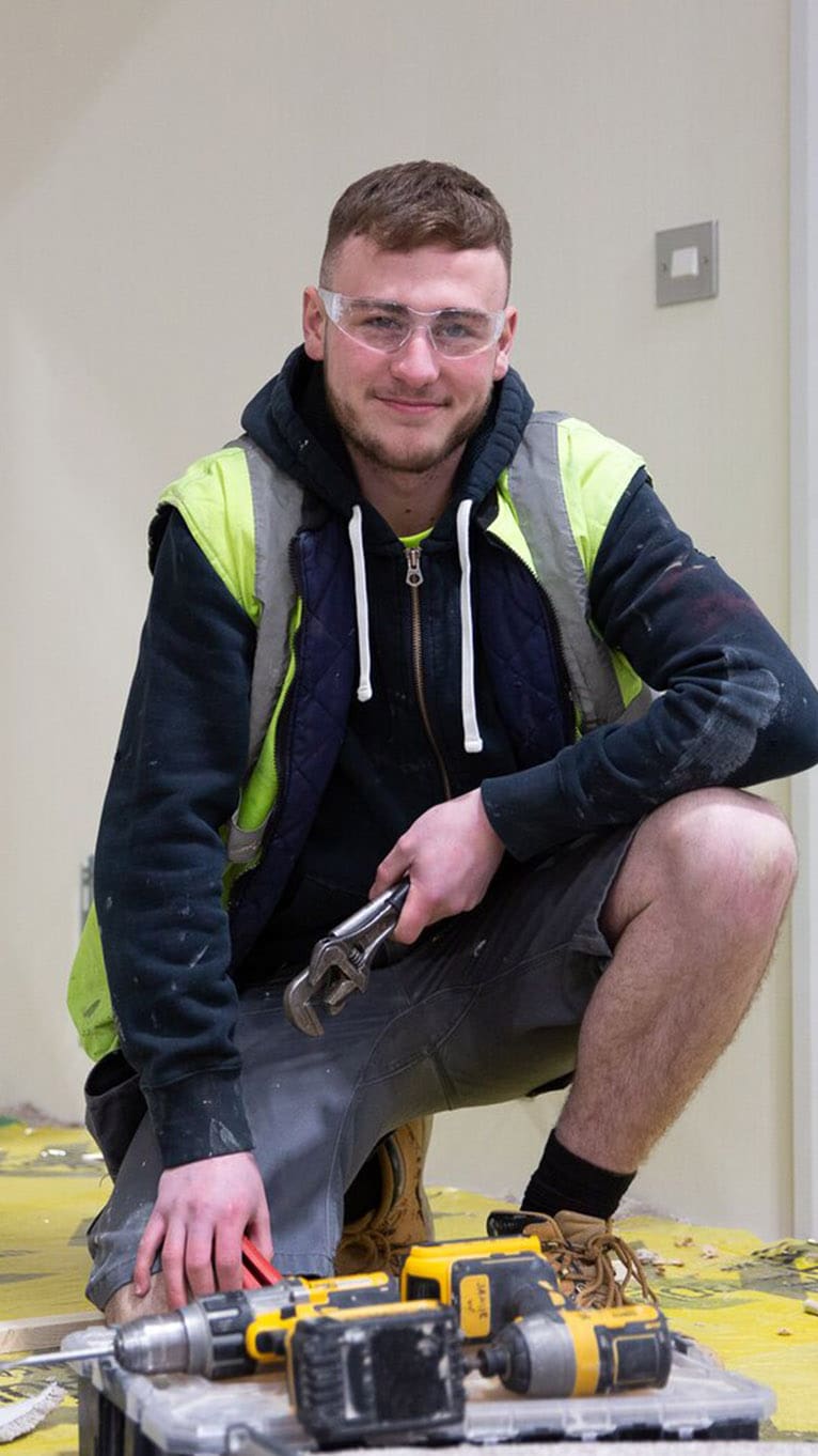 Apprentice with construction tools in workplace