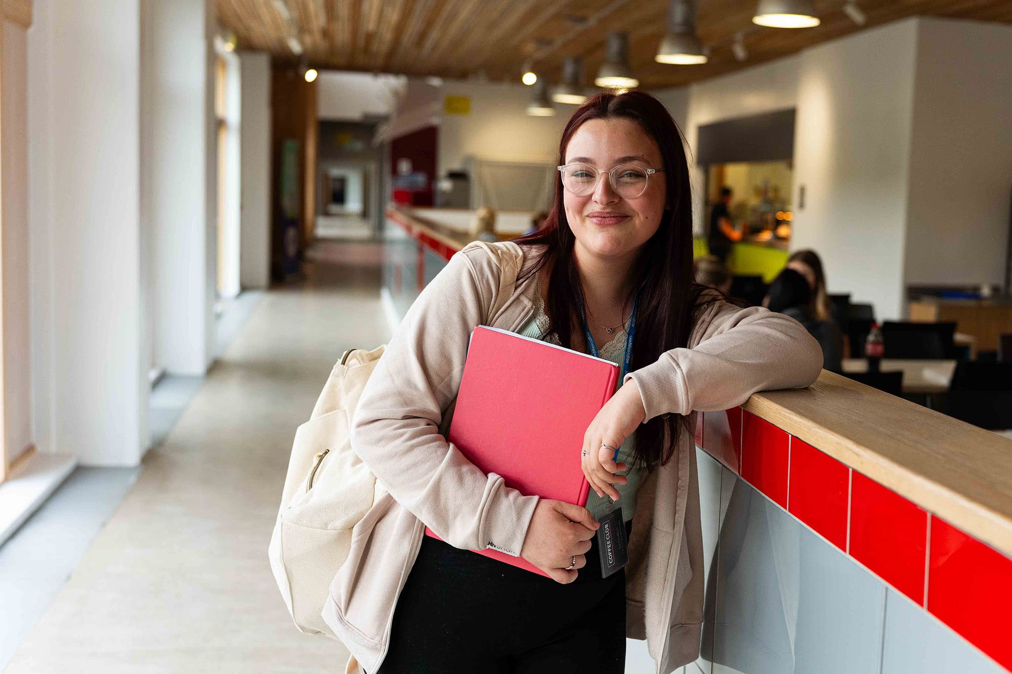 Student leaning on wall with folder at BGLZ