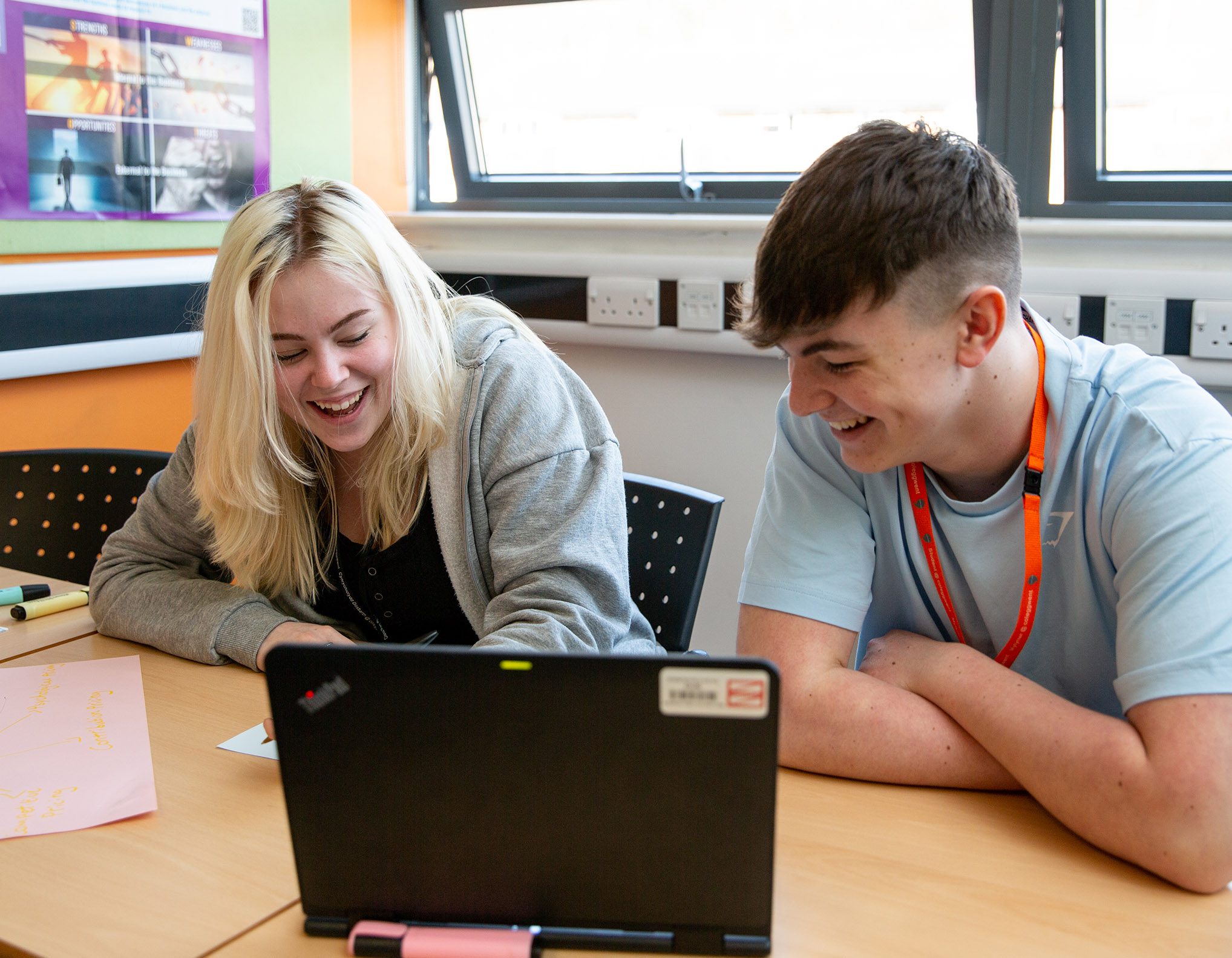 Students sat in front of laptop laughing